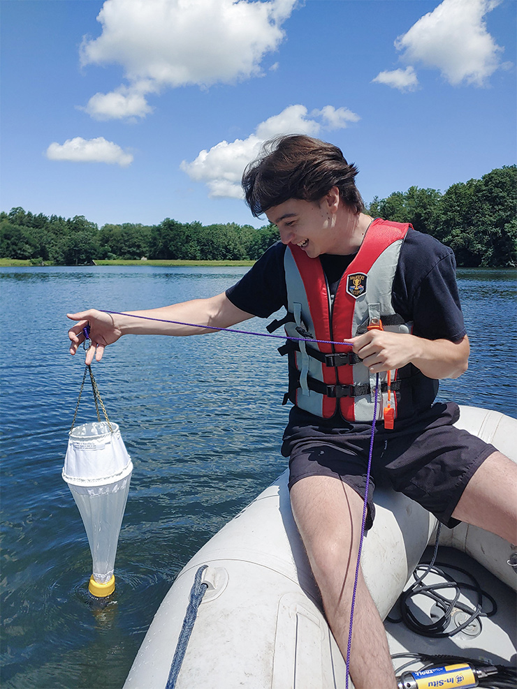 William Damiani uses a plankton net to collect samples of algae and zooplankton at the village of Fredonia water reservoir. The samples will be examined on a microscope at a Fredonia Science Center lab. 