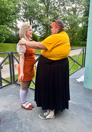 Haylee Morris fluffing the sleeves on Juliana Cianfrini's (Luciana) blouse after coming back from collecting donations at intermission.