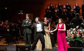 students performing on stage with orchestra and chorus