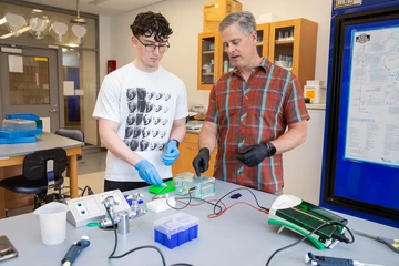 Gradimir Mesarich, a junior Molecular Genetics major, and Associate Professor Scott Ferguson discuss a procedure to determine if a segment of DNA is amplified.