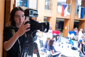 Emily Neiswonger scans the Williams Center Multipurpose Room as she sets up a video camera to record the NASA/GLOBE student presentations.