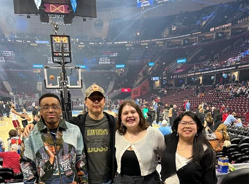 Gathering near their seats at Rocket Arena are (from left): Jaivon Eggleston, Dr. Sungick Min, Sarah Conner and Sonja Green.
