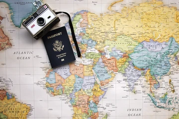 passport booklet and camera on a world map