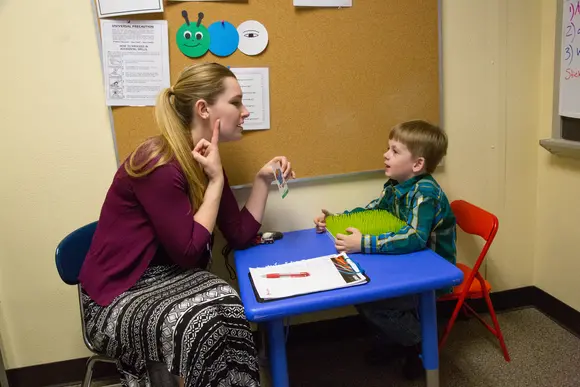 Fredonia speech pathology major working with a young child. Fredonia students have hundreds of scholarships available to them, and every year Fredonia offers tens of millions in aid to students. 