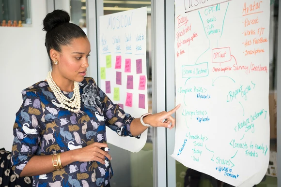 Professional woman in boardroom. Strategic communications degrees help students understand the power and purpose of marketing. 