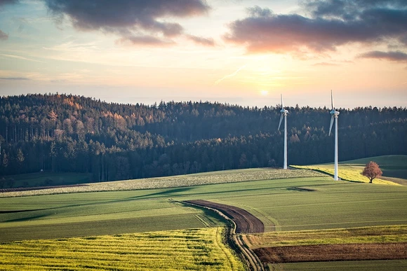 field with wind turbines and mountains. Students who study earth science prepare themselves for careers in a changing world. 