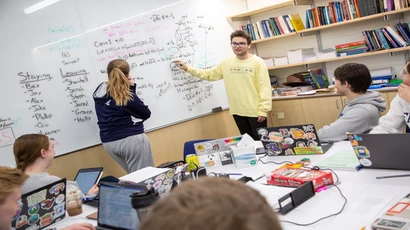 Math club members doing a problem on a whiteboard