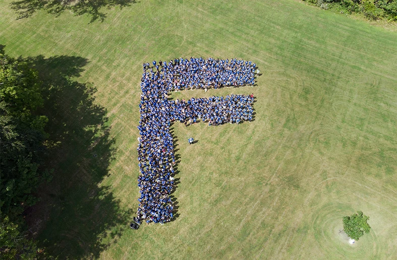 students lined up in the letter F on the lawn