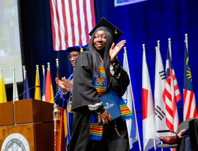 student walking across the platform at Commencement