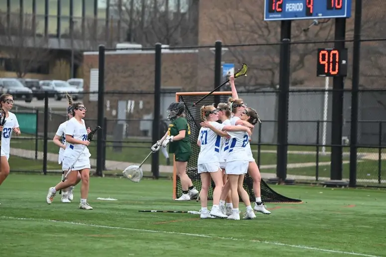 women playing lacrosse at SUNY Fredonia field