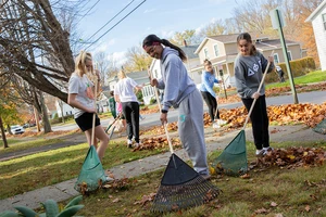 students raking leaves