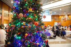 room with Christmas tree and people creating crafts