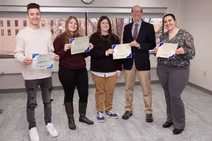 Four student scholarship recipients with George Simmons