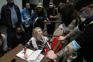 Gayle Petri (seated) discusses promotional ideas for the Lend a Paw for Autism dog walk with students enrolled a Music Industry course