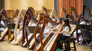 youngsters playing the harp on stage