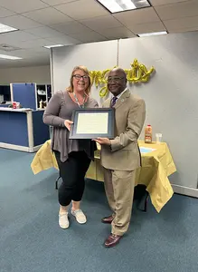 President Stephen H. Kolison Jr. presents the Poummit Secretarial Award to Karly Sutton, a program aide in the Registrar’s Office.