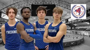 track and field athletes in a group with track in background