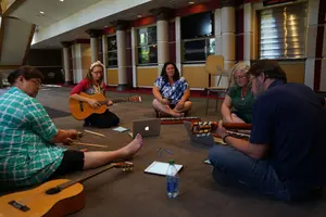 Dr. Jill Reese playing guitar with other musicians