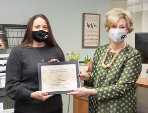 Amy Schmitt receives the Poummit Secretarial Award certificate from Associate Provost Judith Horowitz