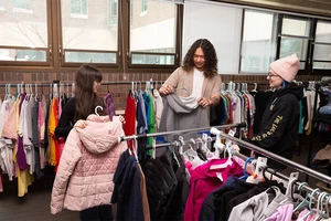 Rylee Crandall (right), Thrift Room manager, assists Christian Taber,  resident director of Eisenhower Hall, from Cheektowaga, N.Y., and Krystyna Klos, a senior majoring in Adolescence Education: Social Studies and History, with a minor in Museum Studies, from Long Island, N.Y., as they browse clothes racks.