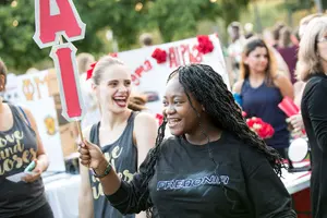 student at Activities Night holding sign