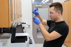 Kevin Aumiller works in a lab in the Science Center.