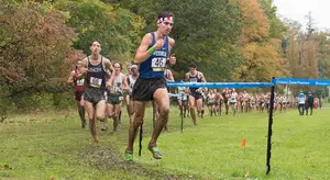 Ethan Francis leads a pack of runners on the muddy 8,000 campus course