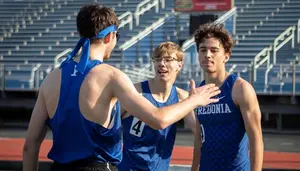 three runners on the track congratulate each other