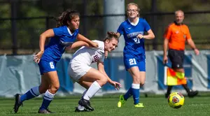 Sydney Tanner tangles with a Potsdam player while Karen Johnson looks on