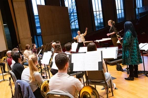 student musicians working with conductor and guests in King Concert Hall