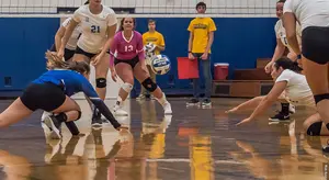 Volleyball players Rachel Aiello and Kailey Falk give an extra effort.