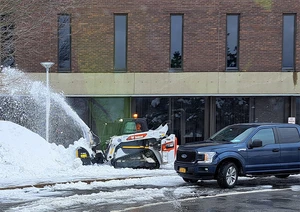 skid steer with snowblower plowing near Mason Hall