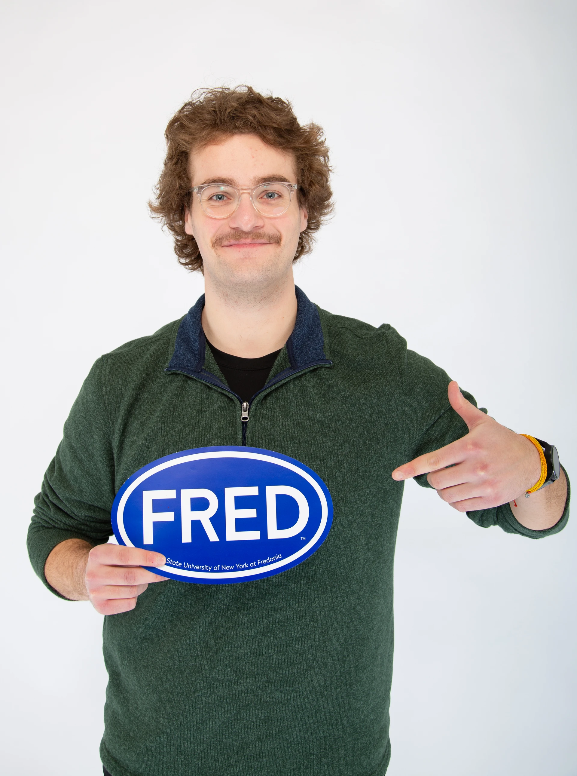Dominik Zimmer, an environmental science student in STEM holding a FRED sign
