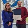 Ethan Smith holding his award certificate, joined by Chautauqua Hall Residence Director Donna Good