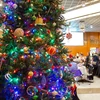 room with Christmas tree and people creating crafts