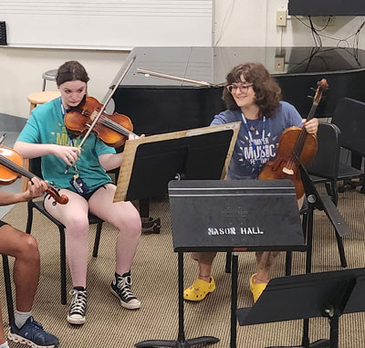 young musicians practice with student teacher